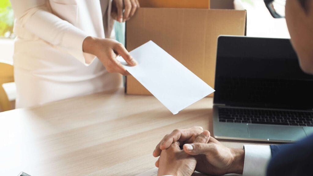 Person handing in a redundancy note to demonstrate redundancies.
